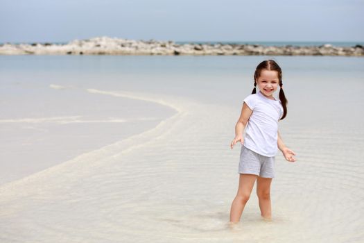 Adorable little girl have fun on the beach