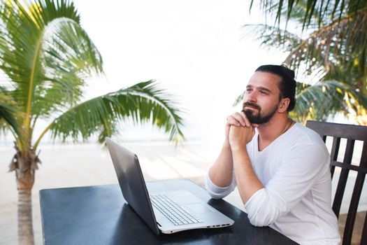 telecommuting, businessman relaxing on the beach with laptop and palm, freelancer workplace, dream job