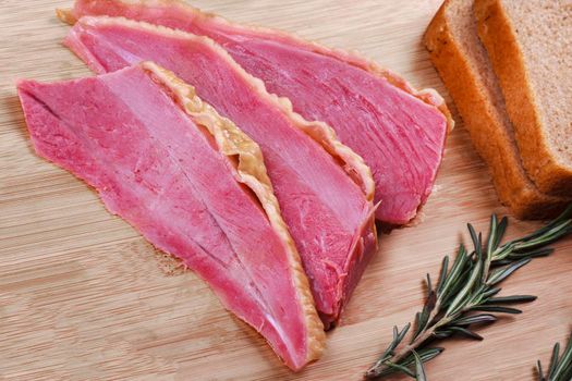 Homemade ham meat sliced and bread on wooden desk.