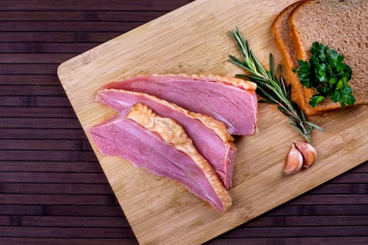 Homemade ham meat sliced and bread on wooden desk.