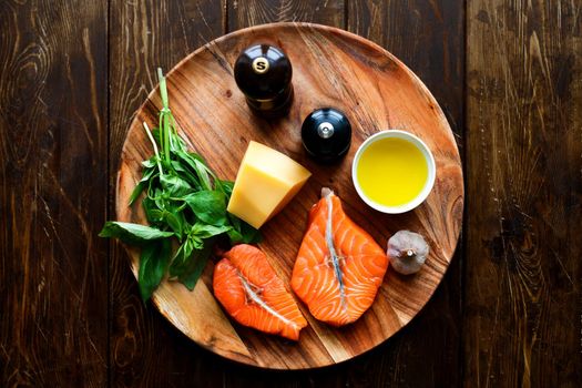 Raw humpback salmon steaks, cheese, rustic wooden background, above view. Fillet with fresh ingredients for tasty cooking and frying pan. Top view. Healthy and diet food concept.