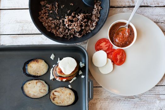 Ingredients for cooking Parmigiana di melanzane: baked eggplant - italy, sicily cousine. On the wooden table.