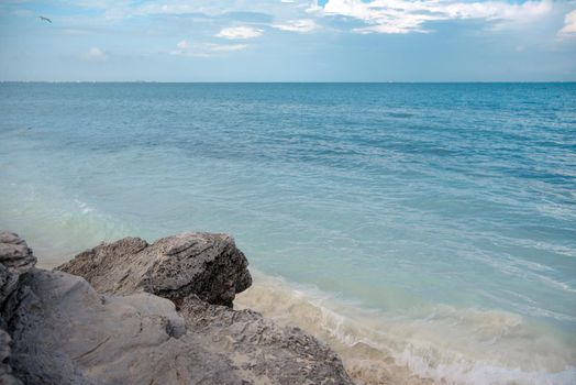 The coastline of the Caribbean Sea with white sand and rocks in Cancun.