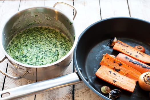 Ingredients for cooking Spinach soup with carrot and croutons in bowl on wooden table