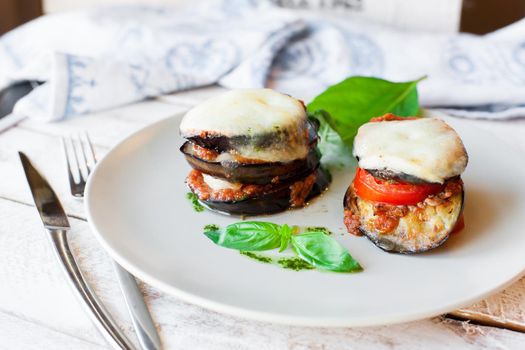 Parmigiana di melanzane: baked eggplant - italy, sicily cousine. On the wooden table.