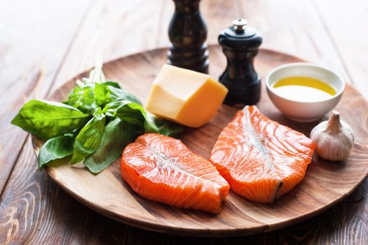 Raw humpback salmon steaks, cheese, rustic wooden background, above view. Fillet with fresh ingredients for tasty cooking and frying pan. Top view. Healthy and diet food concept.