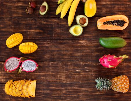 Fresh Tropical fruit on dark wooden background, top view