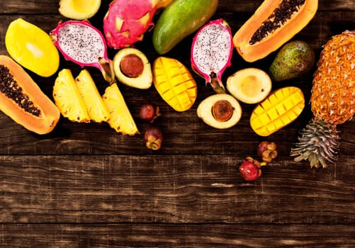 Fresh Tropical fruit on dark wooden background, top view