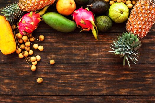 Fresh Tropical fruit on dark wooden background, top view