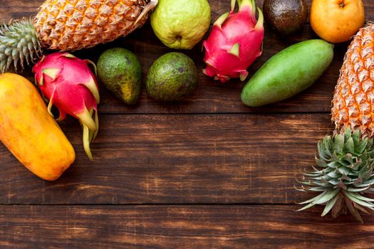 Fresh Tropical fruit on dark wooden background, top view