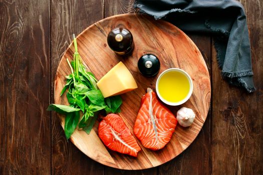 Raw humpback salmon steaks, cheese, rustic wooden background, above view. Fillet with fresh ingredients for tasty cooking and frying pan. Top view. Healthy and diet food concept.