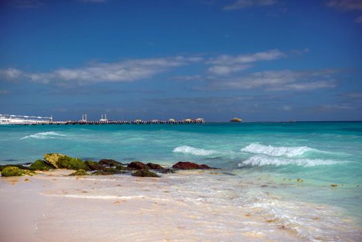 The coastline of the Caribbean Sea with white sand and rocks in Cancun.