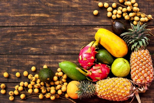 Fresh Tropical fruit on dark wooden background, top view