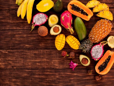 Fresh Tropical fruit on dark wooden background, top view