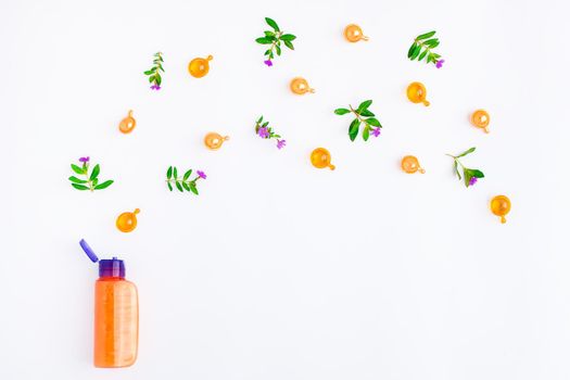 Bottle of essential oil with fresh meadow herbs and flowers on white background. Flat lay, top view, natural