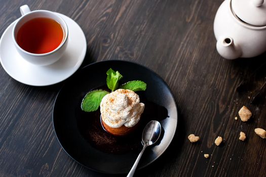 Breakfast time . Tea and cake with cream, garnished with mint leaves