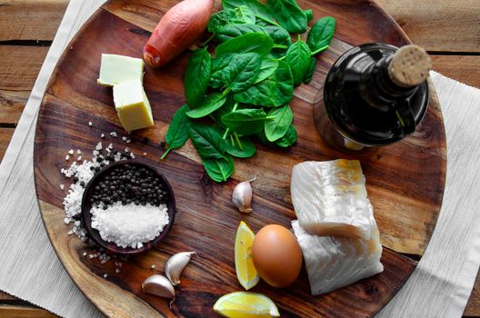 Poached mackerel fish, spinach and egg salad on a dark background, top view. Delicious healthy food concept