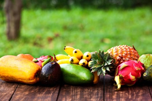 Fresh Tropical fruit on dark wooden background, top view