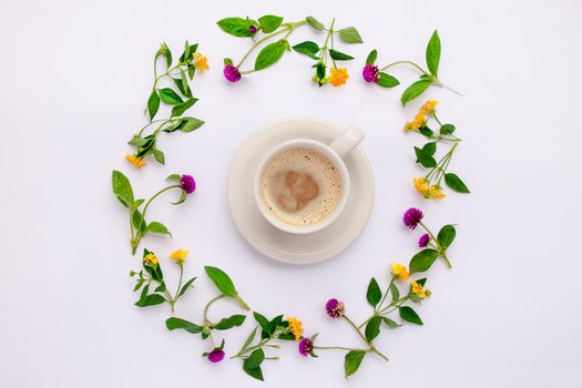 Meadow flowers and wildflowers arranged in circle with coffe cup. Flat lay.