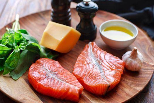 Raw humpback salmon steaks, cheese, rustic wooden background, above view. Fillet with fresh ingredients for tasty cooking and frying pan. Top view. Healthy and diet food concept.