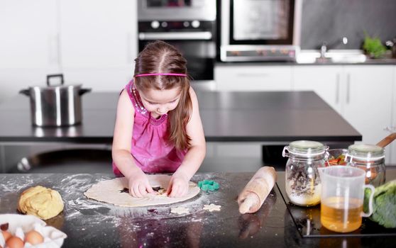 Sweet little cute girl is learning how to make a cake, in the home modern kitchen, Family concept