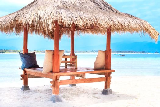 White wooden shelter with straw roof from the sun on the beach in Bali or Thailand. Gili island