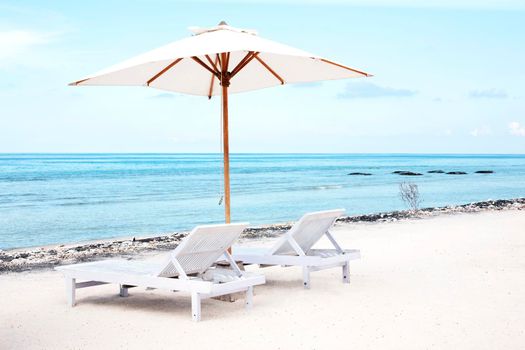 Beach Sun chairs and parasol on exotic tropical white sandy ocean beach