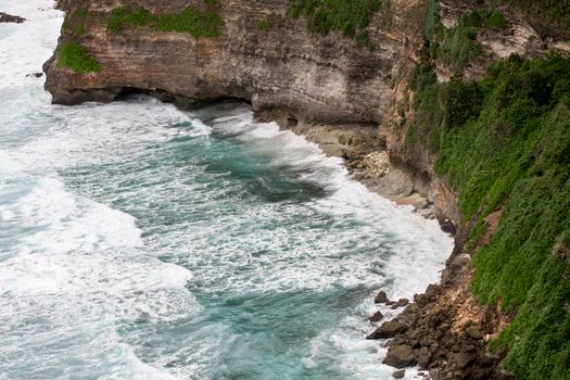 Cliffs above blue tropical sea with green landscape. Nusa Dua. Uluwatu Bali Indonesia