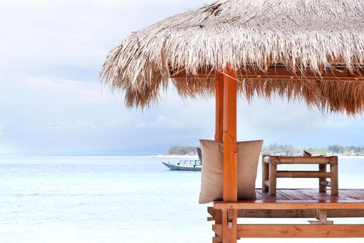 White wooden shelter with straw roof from the sun on the beach in Bali or Thailand. Gili island