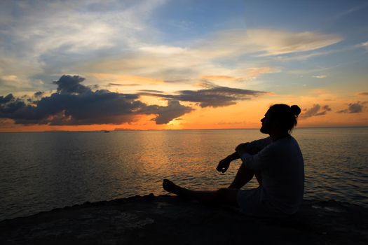 Yoga scene man silhouette in sunset background.