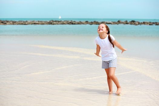 Adorable little girl have fun on the beach