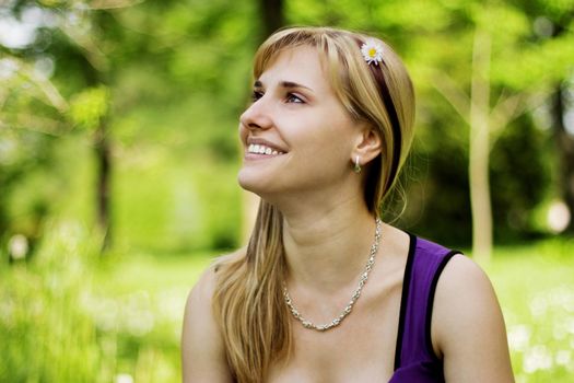 Portrait of a young smiling woman walking in the park.