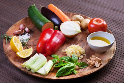 Ingredients vegetables for soup with pesto sauce and basil on a wooden plate. Stock image.