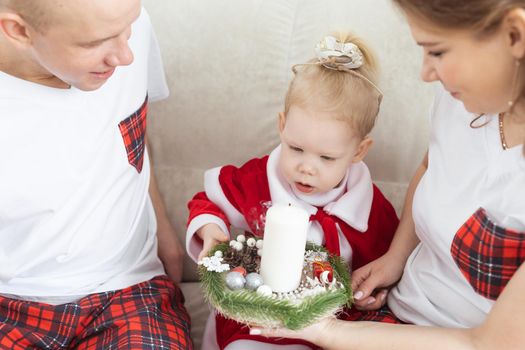 Baby child with hearing aid and cochlear implant having fun with parents in christmas room. Deaf and health