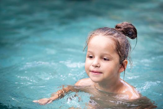 Happy Pretty little girl in swimming pool outdoor