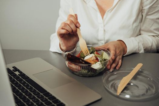 Unrecognisable Female Employee Having Lunch in Office, Woman Eating Salad at Working Place