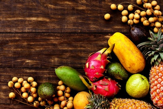 Fresh Tropical fruit on dark wooden background, top view