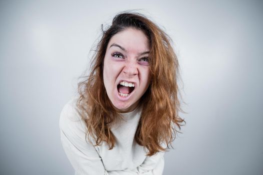 Close-up portrait of insane woman in straitjacket on white background