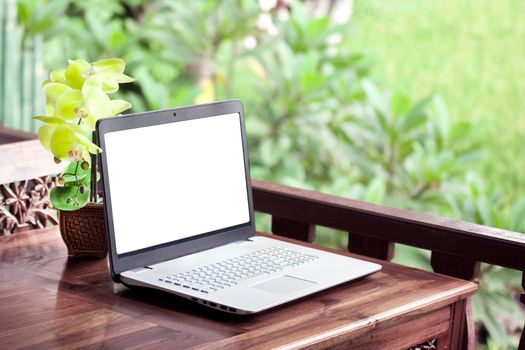 Laptop on wooden table nature. Asia garden