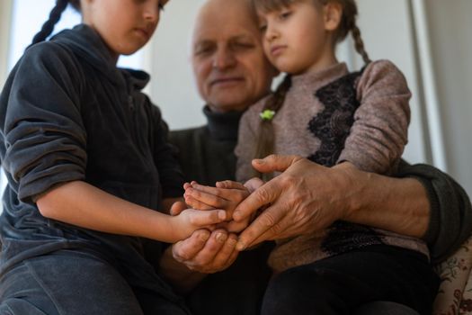 Hands of the old man and a child's hand