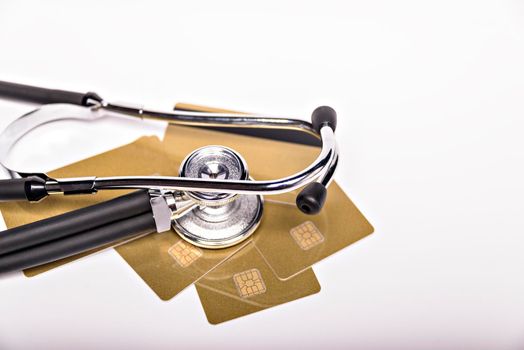 Health care costs conceptual image: stethoscope and pile of money on a medical chart, symbol of health care costs or health insurance, isolated on white background