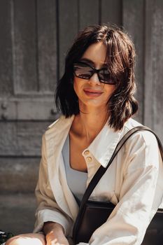Vertical Portrait of Fashionable Young Brunette Woman in Sunglasses Outdoors