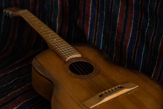 spanish guitar on a old chair with wooden background horizontal.
