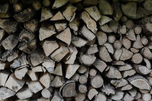 pile stacked natural sawn wooden logs background. Background of birch logs, stacked on top of each other. Wall of stacked wood logs as background