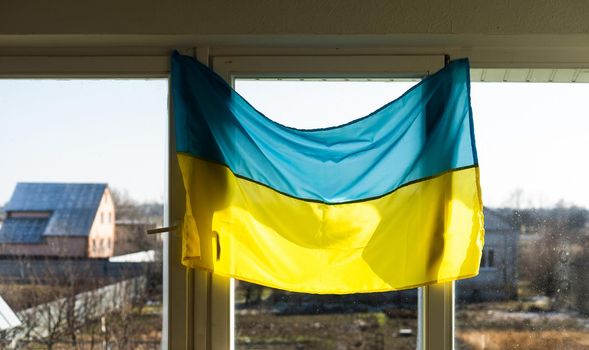 Support Ukraine. Ukrainian flag on the window. Place for text