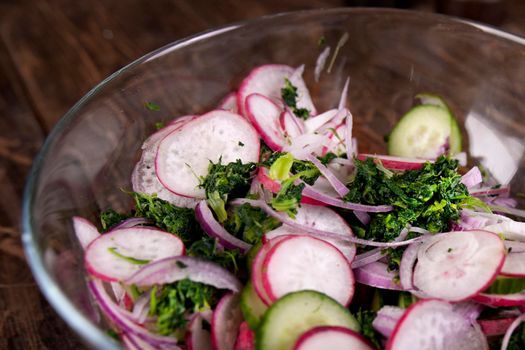 Ingredients. Broiled salmon with radish and spinach, served on wooden table. View from above, top studio shot