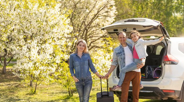 parents and child stopped for break by car. happy family travels by car. Car travel concept. healthy family.