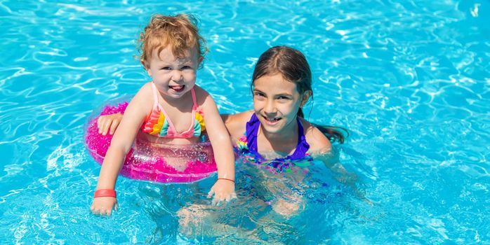 A children swims in a pool with a circle. Selection focus. Kid.