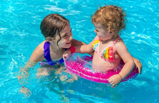 A children swims in a pool with a circle. Selection focus. Kid.