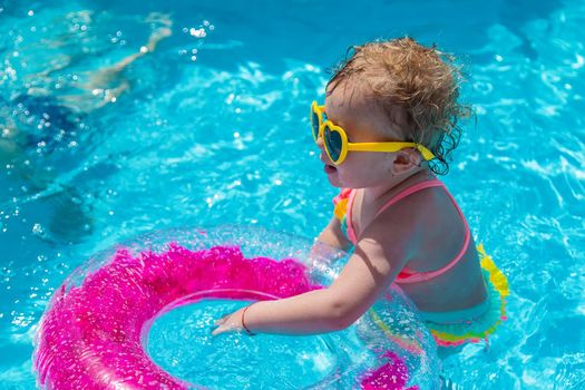 A child swims in a pool with a circle. Selection focus. Kid.